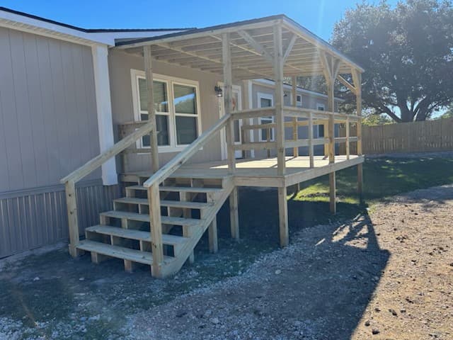 Covered 12x12 wood porch with steps built onto a home in Huntsville, TX