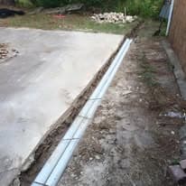 River rock drainage swale directing runoff away from a home's foundation in Huntsville, TX