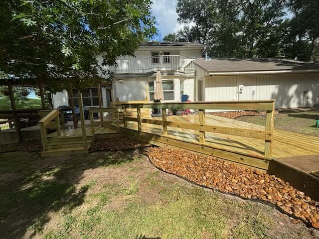Wood deck and ramp with handrails built onto the back of a two-story home in Huntsville, TX