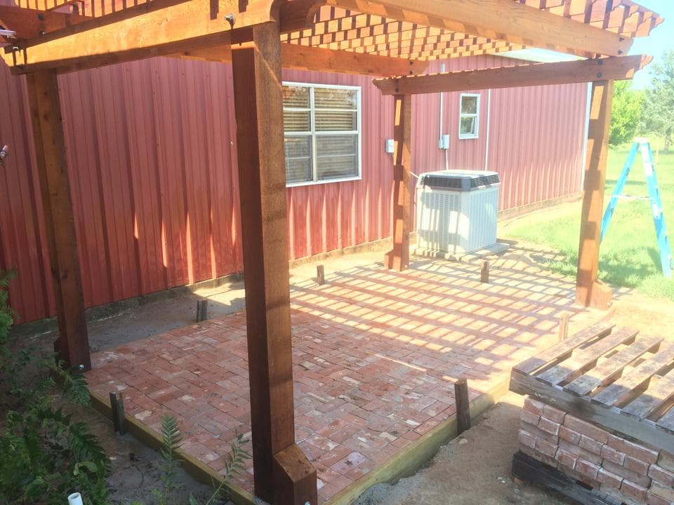 Custom cedar pergola under construction over a brick paver patio built by Rockin' D Services in Huntsville, TX