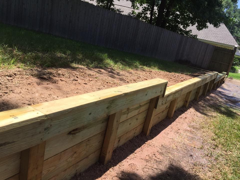 Close-up of professionally built wood retaining wall posts and boards installed by Rockin' D Services