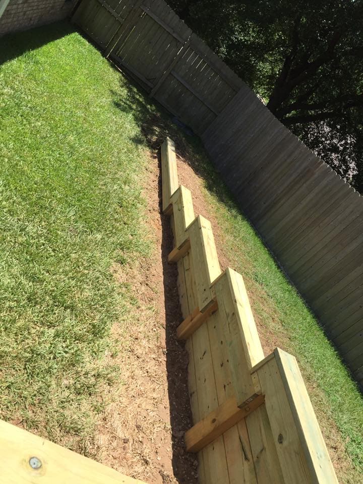 Tiered wood retaining wall diagonal view showing stepped post construction in Huntsville, TX