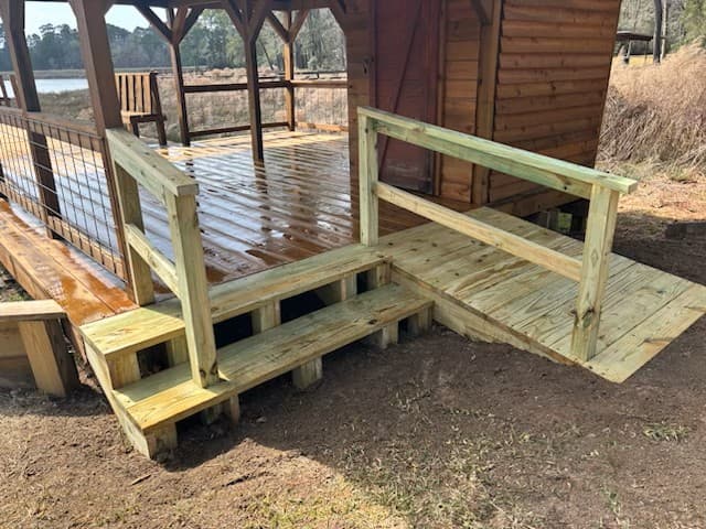 Wood steps and accessibility ramp built onto a lakeside deck and boat dock near Huntsville, TX