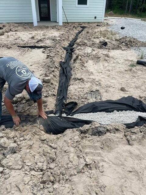 Drain field installation with drainage fabric and gravel by Rockin' D Services in Huntsville TX