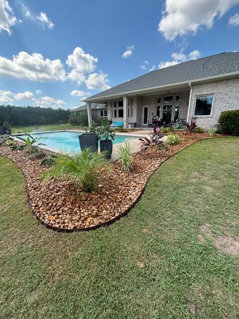 Professional landscaping installation around a swimming pool in Huntsville TX by Rockin' D Services