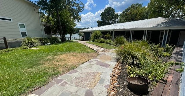 Custom stone patio and lakeside hardscaping by Rockin' D Services in Huntsville TX
