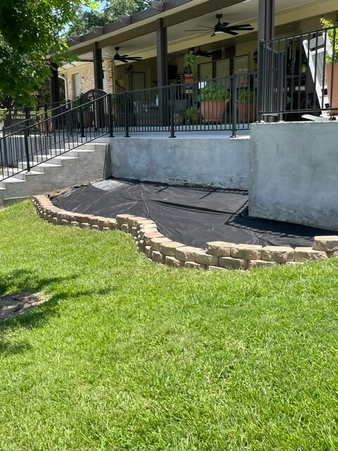 Finished block retaining wall and landscaped outdoor area built by Rockin' D Services in Huntsville TX